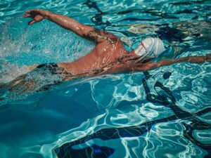 Dynamic shot of a male swimmer training in an outdoor swimming pool.