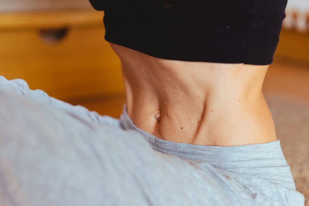 Close-up of a fit person's torso wearing sportswear, emphasizing toned muscles.