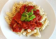 Spirelli pasta topped with rich tomato sauce and fresh greens for a perfect meal.